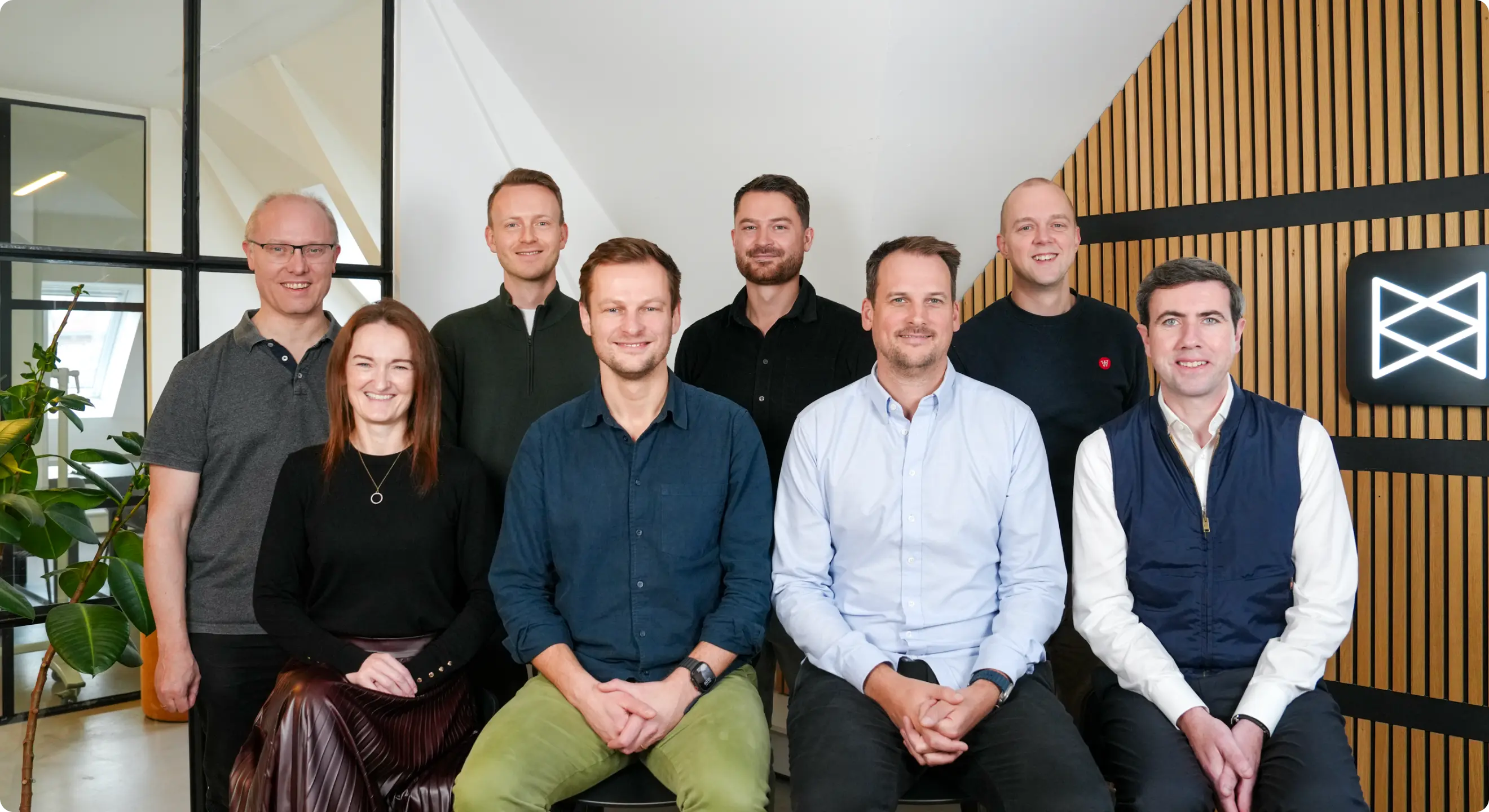 Group of professionals posed in a modern office setting.