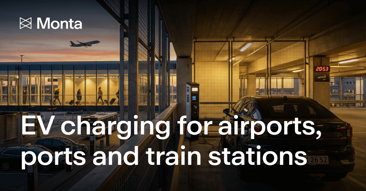 Electric vehicle charging station in a multi-storey car park at dusk, with an airport terminal visible in the background.