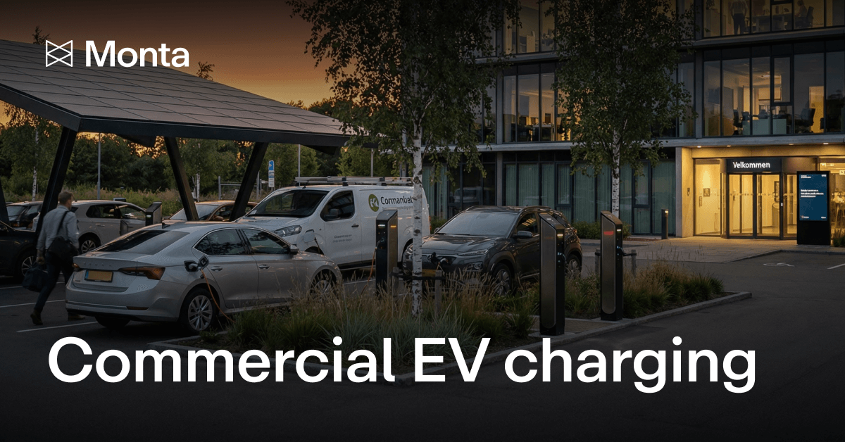 Commercial electric vehicle charging station at dusk, featuring parked cars, charging points, and a modern building with illuminated signage.
