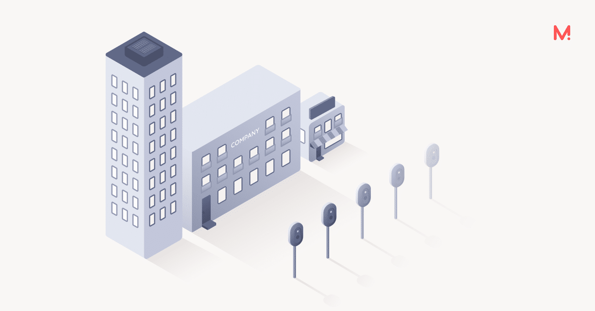 Isometric illustration of an office tower, a company building and a shop, with a row of five charge points on posts beside them.