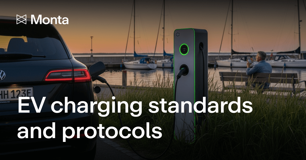 A sleek EV charging station beside a parked car near a marina, with a person seated in the background, under a serene evening sky.