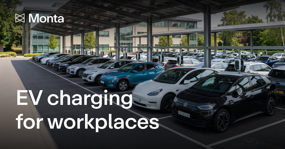 Rows of electric cars parked under a solar canopy in an office car park, each bay fitted with a wall-mounted charge point.