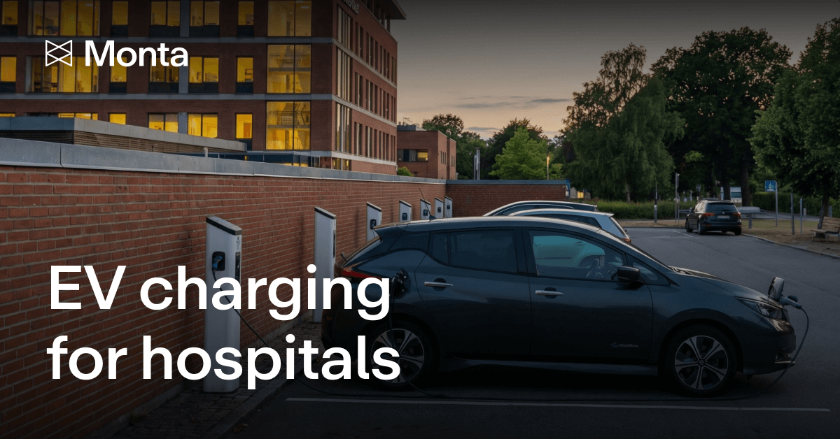 EV charging stations installed outside a hospital, with parked cars and a modern building in the background, under evening light.