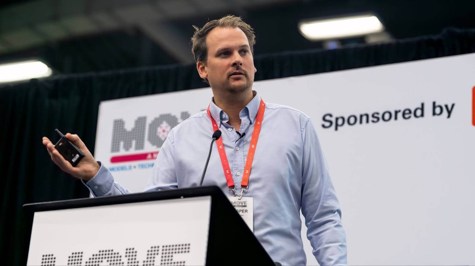 A man in a light blue shirt speaking from a lectern on stage, with MOVE America 2024 event branding behind him.