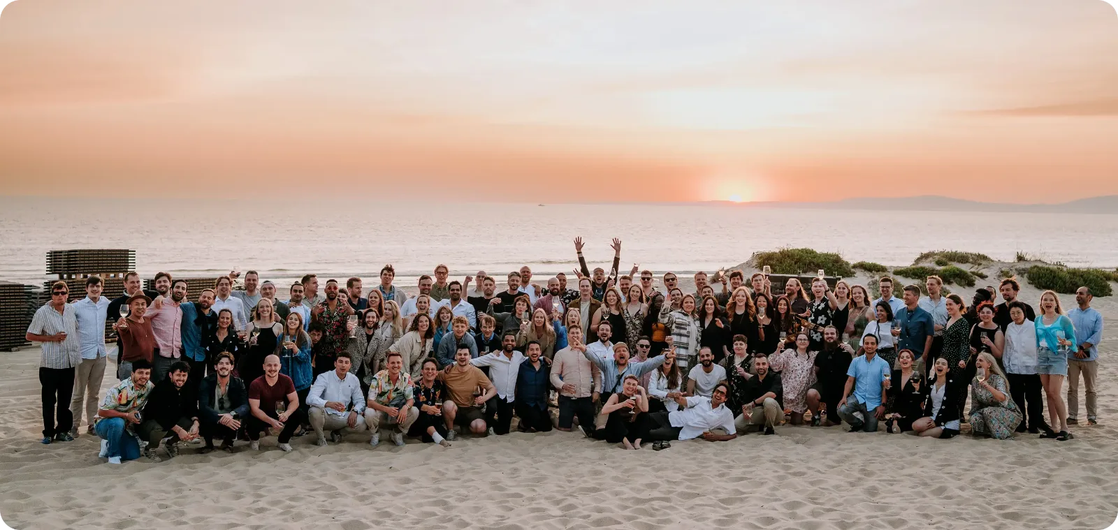 The Monta team gathered on a beach at sunset